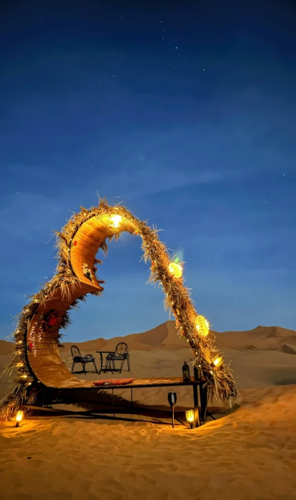 A heart-shaped seating area decorated with reeds and lights in the camp where you will be staying during your Marrakech Desert tour.