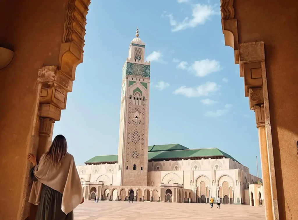 View of the Hassan II Mosque and its minaret framed by a decorative arch in Casablanca, Morocco