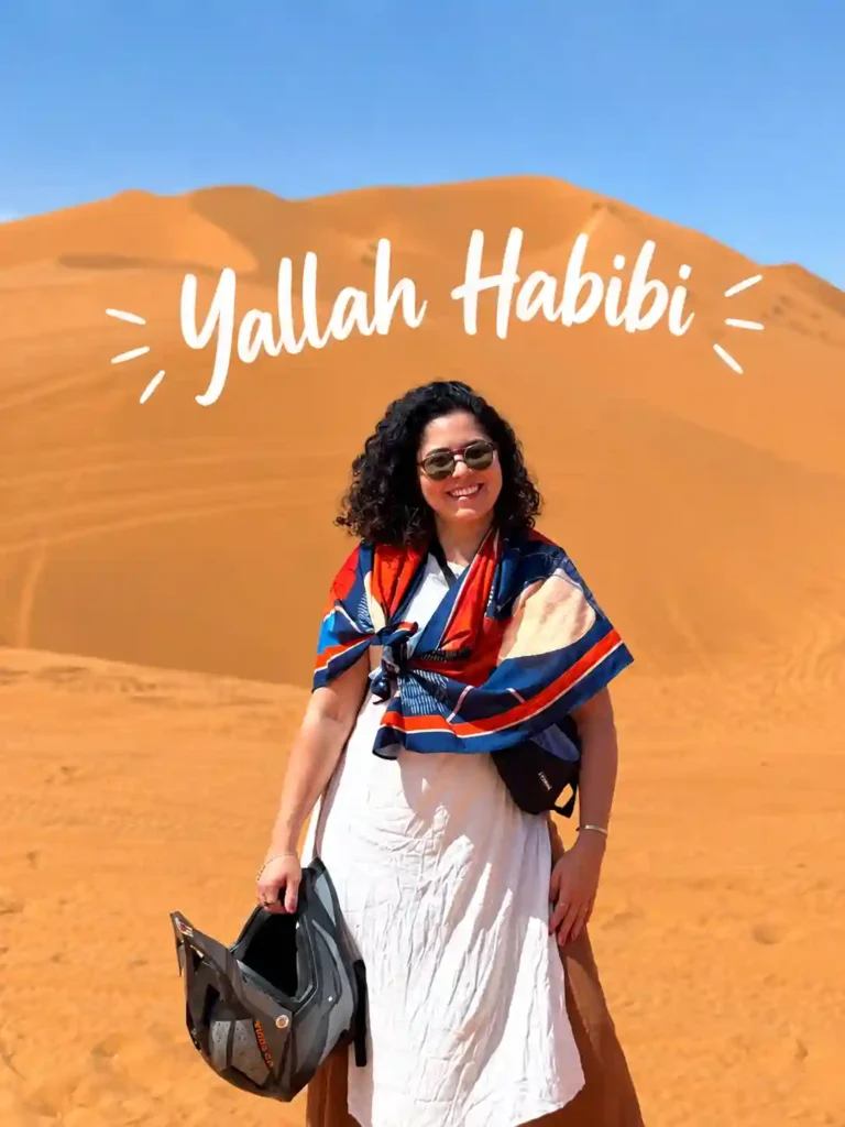 Yalla Habibi moment in the Moroccan Sahara Desert with a traveler standing among the beautiful golden sand dunes of Merzouga